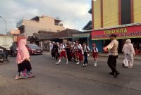 Anggota Polsek Bayongbong Polres Garut Dampingi Hari Pertama Kembalinya Siswa Ke Sekolah
