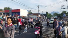 Caption : Polsek Leles jamin keselamatan warga dengann menyebrangkan pejalan kaki