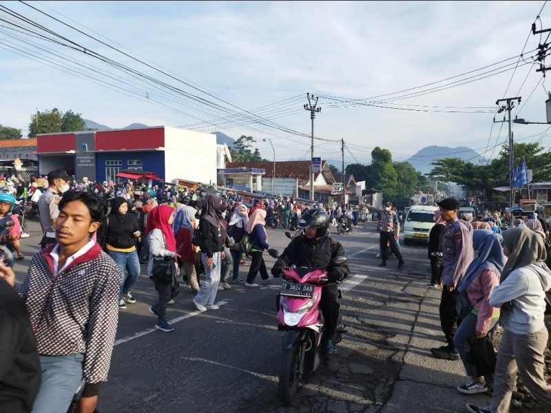 Caption : Polsek Leles jamin keselamatan warga dengann menyebrangkan pejalan kaki