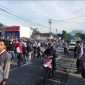 Caption : Polsek Leles jamin keselamatan warga dengann menyebrangkan pejalan kaki