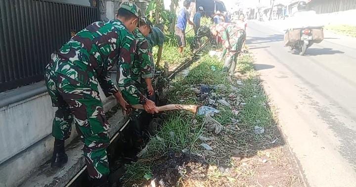 Anggota Koramil 1113/Bayongbong, Kodim 0611/Garut sedang membersihkan parit yang tersumbat
