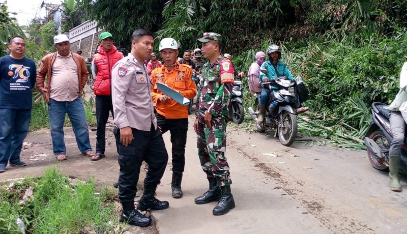 |Bhabinkamtibmas dan Babinsa Desa Barusuda, subsektor Cigedug, Polsek Bayongbong, Koramil 1113/Bayongbong bersama sejumlah pihak terkait dan warga sekitar, melakukan pengamanan dan pembersihan material longsor yang menutupi sebagian bahu jalan Cigedug-Cikajang yang dilaksanakan pada hari di Kampung Cikuray, RT 01 RW 09, Desa Barusuda, Kecamatan Cigedug. Minggu (03/03/2025).
